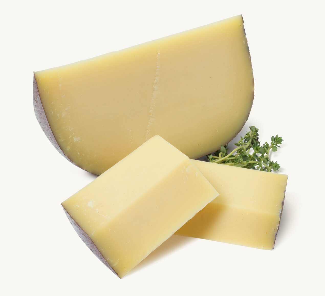 queso-sardo-sin-lactosa-trozo Trozo de queso sardo y dos cortes rectangulares acompañado de ramitas de tomillo fresco